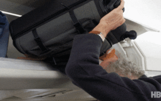 passager essayant de mettre sa valise dans compartiment trop petit